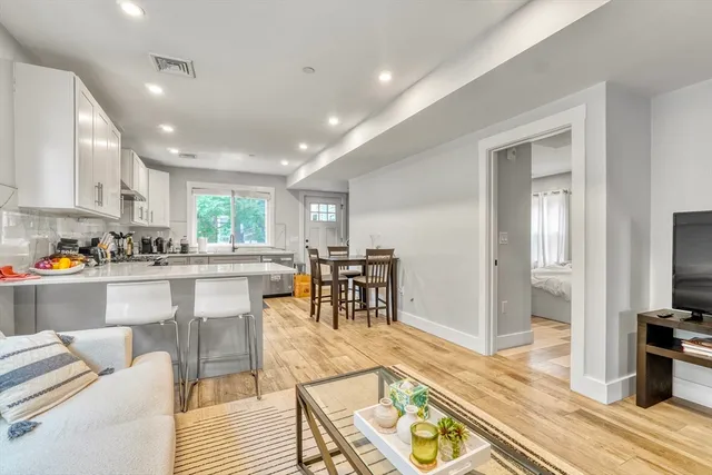a living room with furniture a dining table and a flat screen tv