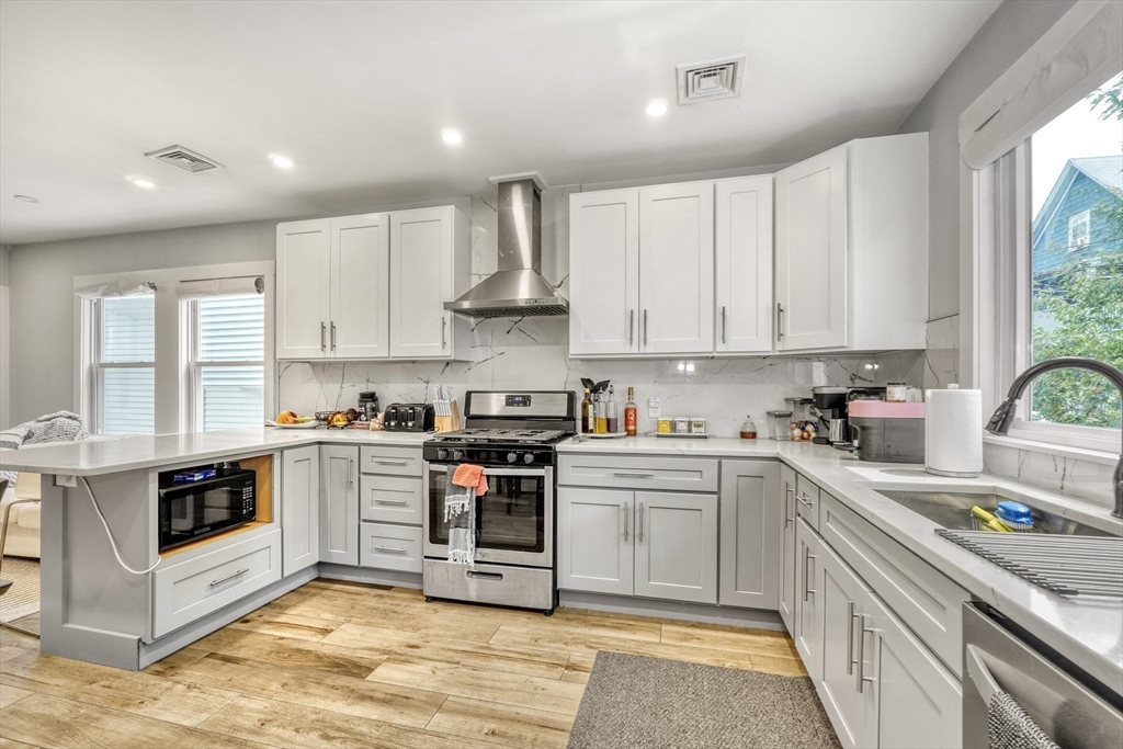 61 Shepton Street Boston, MA 02124 - Photo 4 of 38 a kitchen with stainless steel appliances granite countertop a stove sink and cabinets