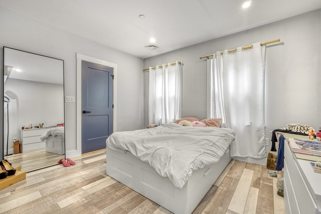 61 Shepton Street Boston, MA 02124 - Photo 6 of 38 a spacious bedroom with a bed and a chandelier