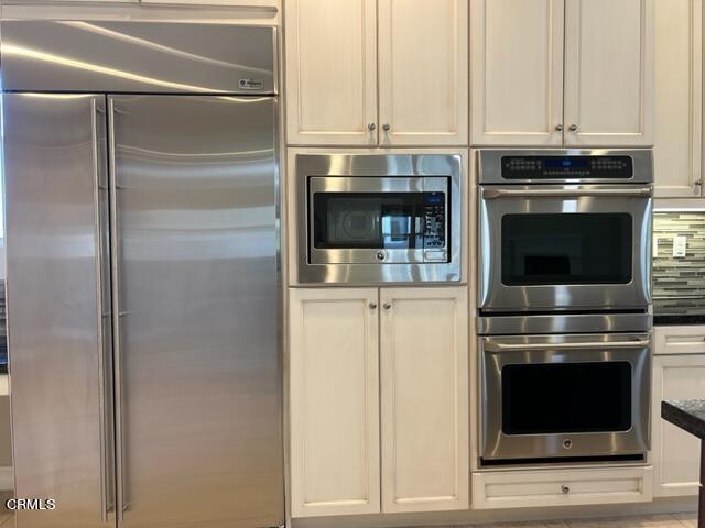 5200 Breakers Way Oxnard, CA 93035 - Photo 20 of 75 a kitchen with granite countertop white cabinets and stainless steel appliances