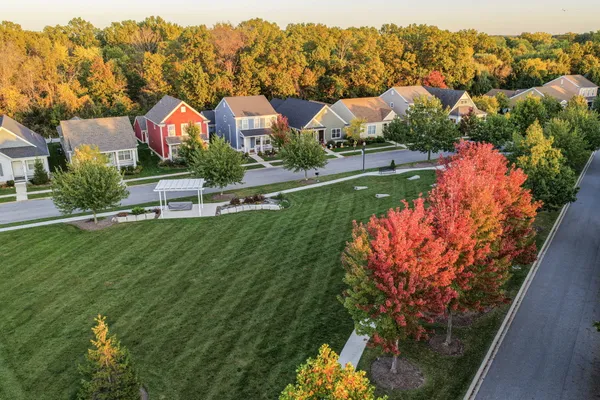 an aerial view of residential houses with outdoor space and trees