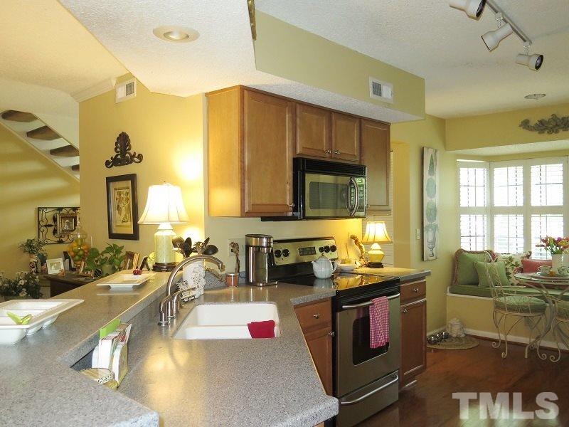 7752 Falcon Rest Circle, Unit 7752 Raleigh, NC 27615 - Photo 8 of 17 a kitchen with sink stove and chairs