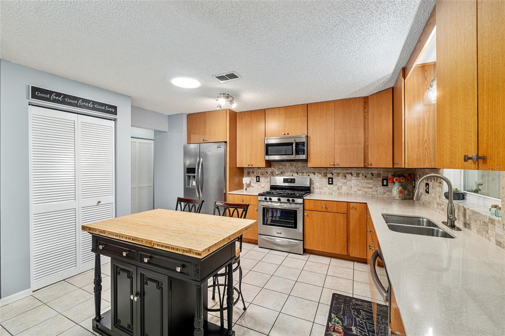 9770 Southwest 97th Place Ocala, FL 34481 - Photo 20 of 64 a kitchen with stainless steel appliances a stove a sink a microwave and cabinets