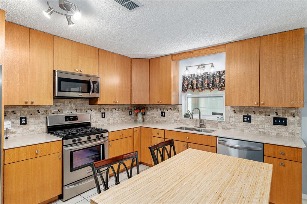 9770 Southwest 97th Place Ocala, FL 34481 - Photo 21 of 64 a kitchen with a sink a stove and a microwave