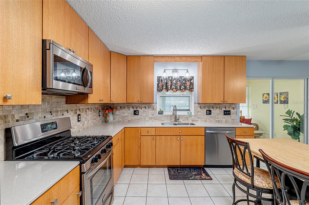9770 Southwest 97th Place Ocala, FL 34481 - Photo 23 of 64 a kitchen with stainless steel appliances a stove a sink a microwave and a refrigerator