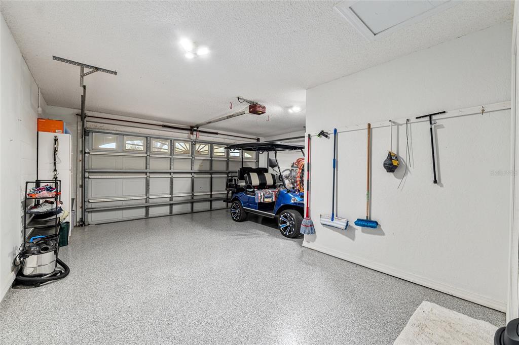 9770 Southwest 97th Place Ocala, FL 34481 - Photo 45 of 64 a view of a garage with furniture and a car parked in it