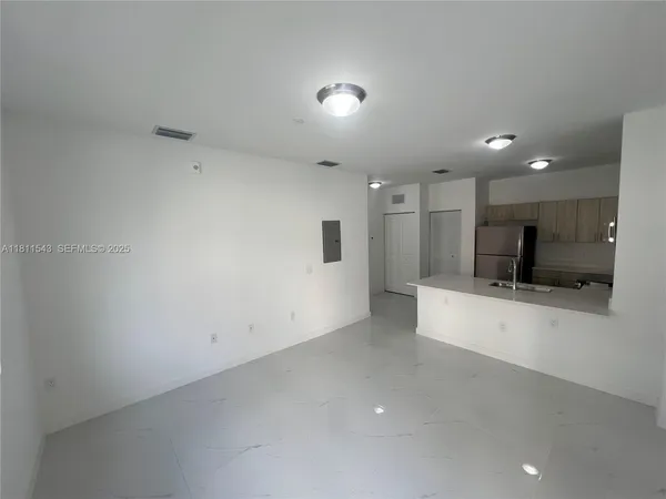 a view of a kitchen with a sink and a refrigerator