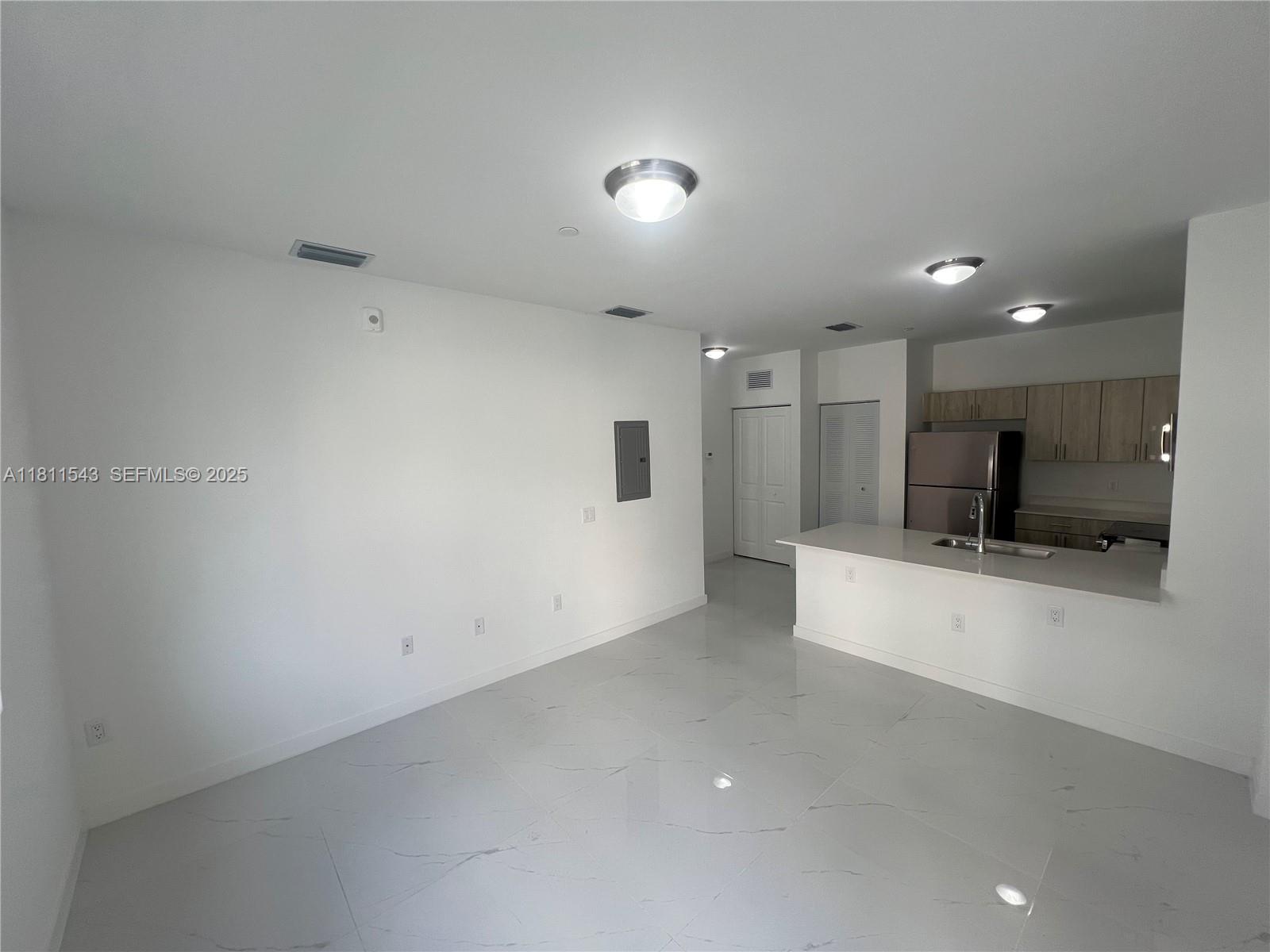 1010 Southwest 69th Avenue, Unit 104 Miami, FL 33144 - Photo 12 of 16 a view of a kitchen with a sink and a refrigerator