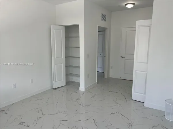 an empty room with closet and mirrors