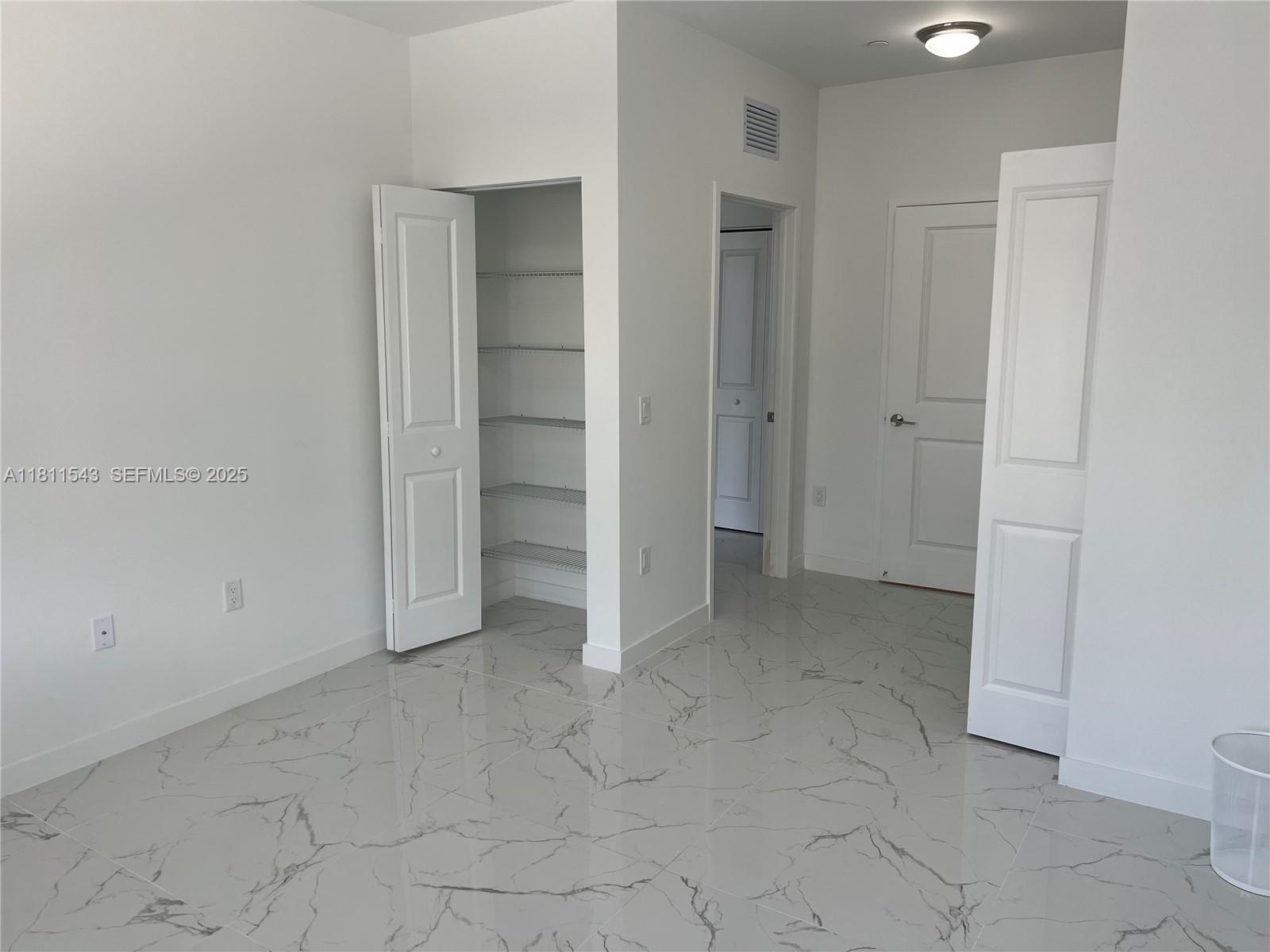 1010 Southwest 69th Avenue, Unit 104 Miami, FL 33144 - Photo 13 of 16 an empty room with closet and mirrors