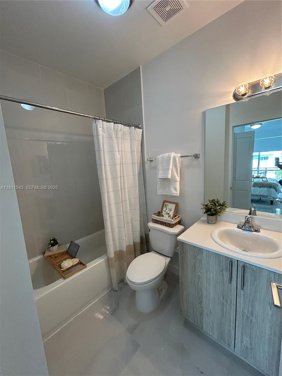 1010 Southwest 69th Avenue, Unit 104 Miami, FL 33144 - Photo 15 of 16 a bathroom with a sink a toilet and a mirror