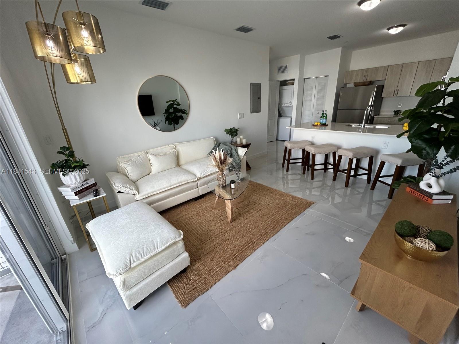1010 Southwest 69th Avenue, Unit 104 Miami, FL 33144 - Photo 2 of 16 a living room with furniture and a chandelier