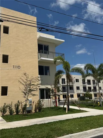 a front view of a building with a garden