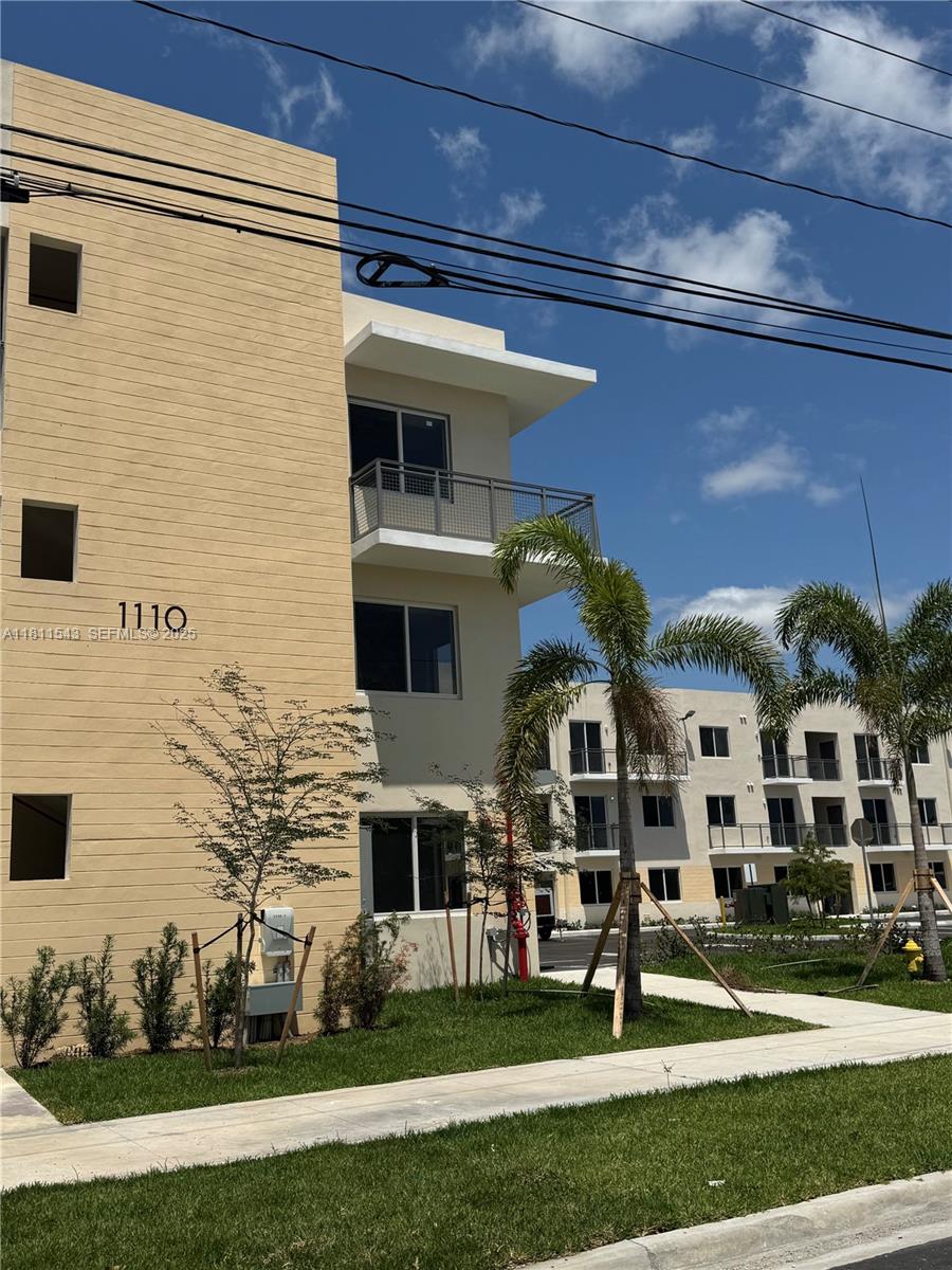 1010 Southwest 69th Avenue, Unit 104 Miami, FL 33144 - Photo 4 of 16 a front view of a building with a garden
