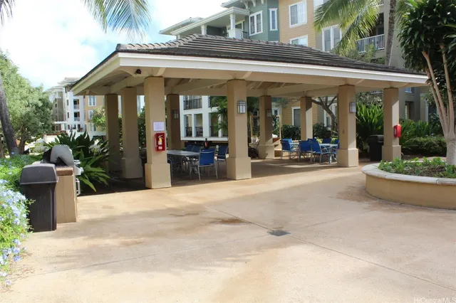 a view of a patio with table and chairs potted plants and floor to ceiling window