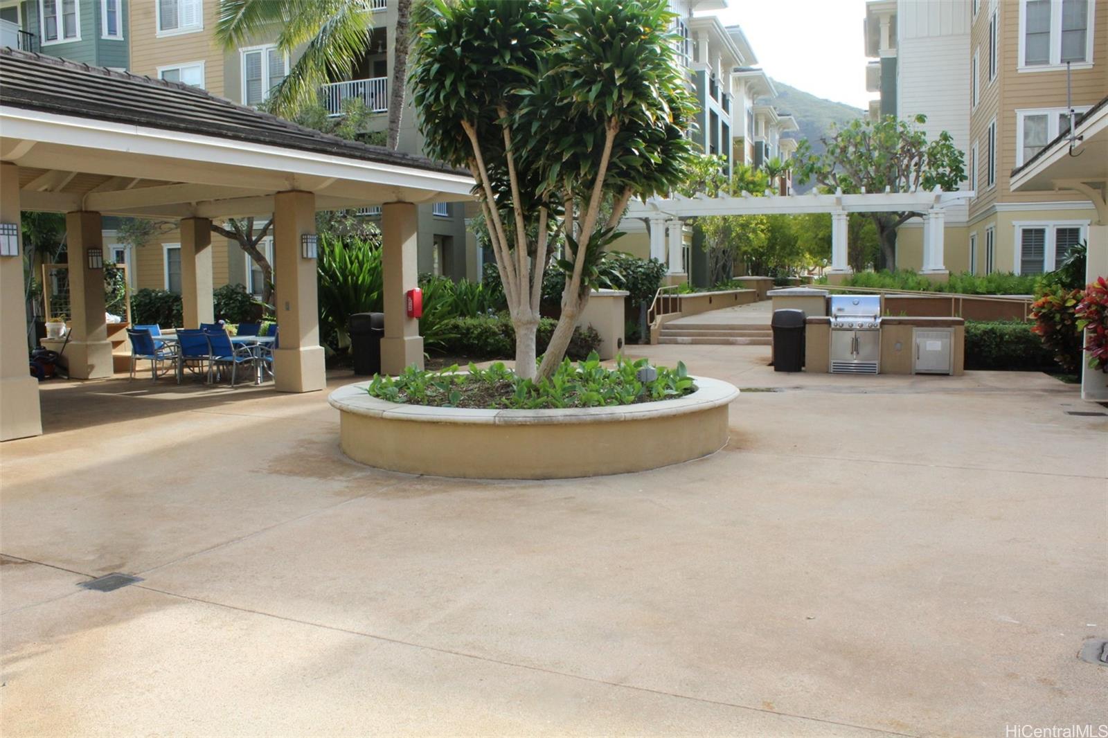 520 Lunalilo Home Road, Unit 7328 Honolulu, HI 96825 - Photo 21 of 22 a view of a patio with table and chairs potted plants and floor to ceiling window