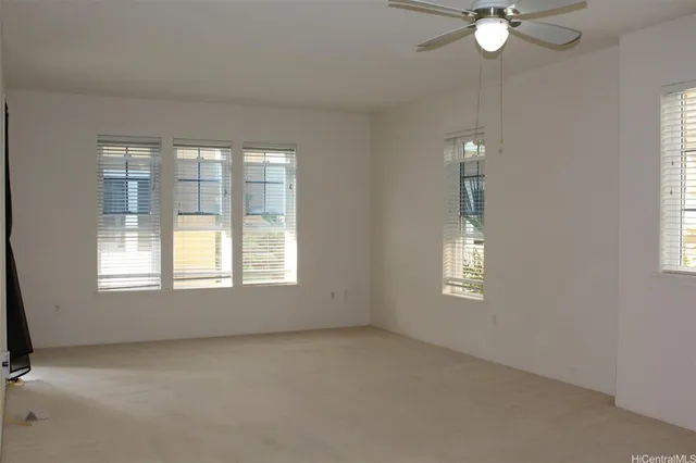 an empty room with windows and fan