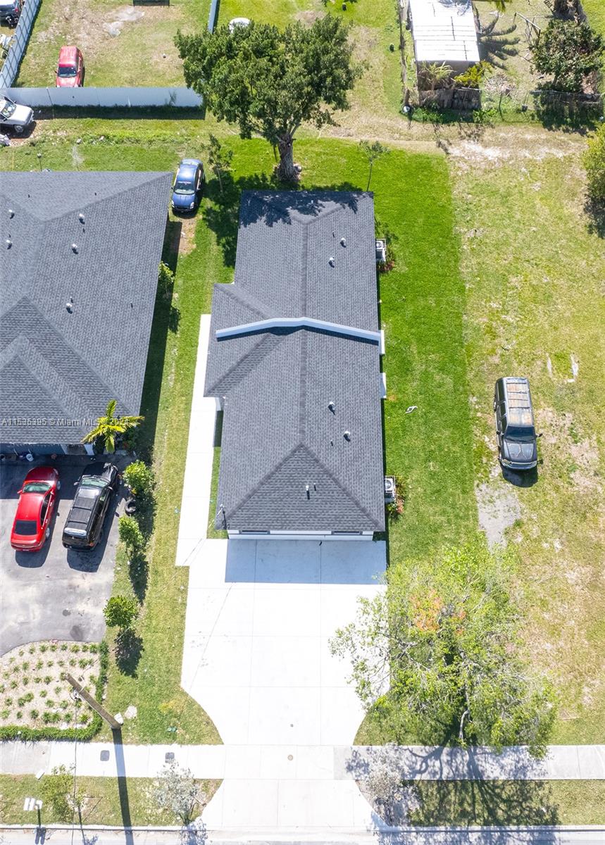 673 Northwest 14th Street, Unit 1 Florida City, FL 33034 - Photo 3 of 20 an aerial view of a house with a garden and a car parked