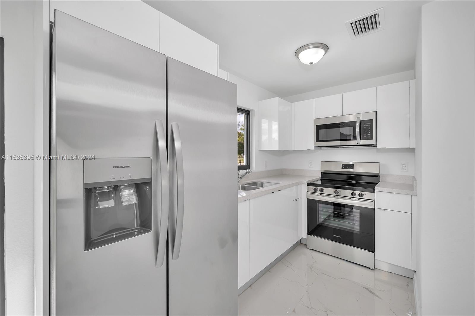 673 Northwest 14th Street, Unit 1 Florida City, FL 33034 - Photo 8 of 20 a kitchen with stainless steel appliances granite countertop a refrigerator a stove and a sink