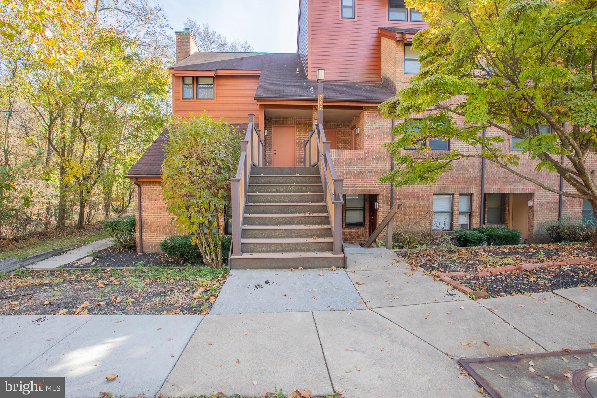 a view of a brick house with many windows next to a road