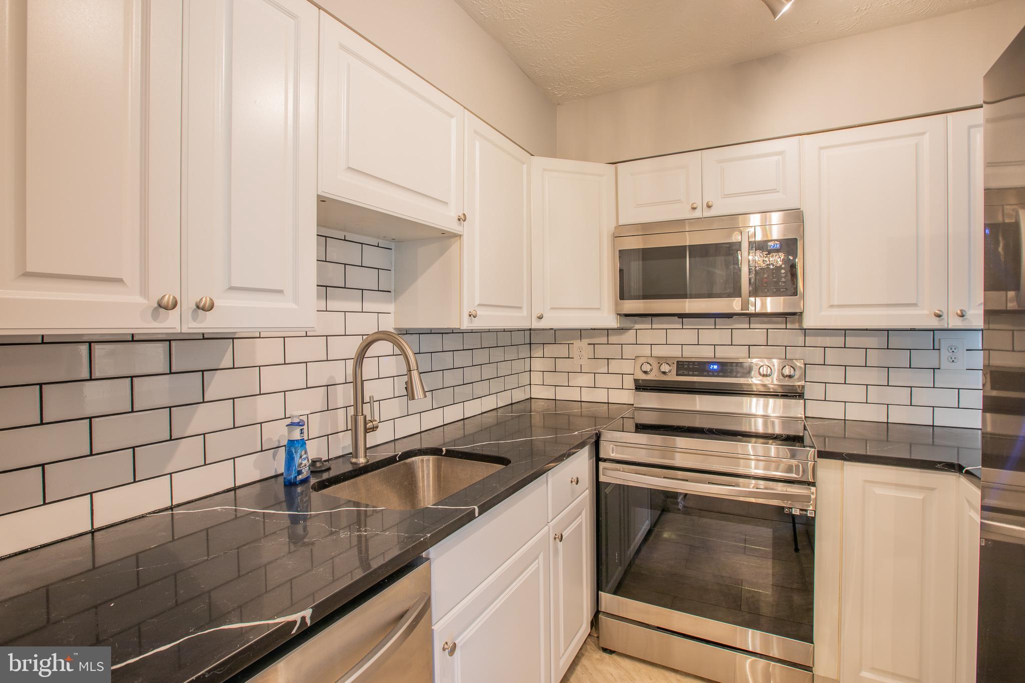 7537 Weather Worn Way, Unit A Columbia, MD 21046 - Photo 11 of 23 a kitchen with granite countertop a sink stainless steel appliances and cabinets
