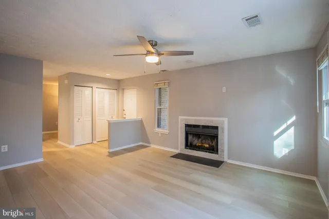 a view of an empty room with a fireplace and a window