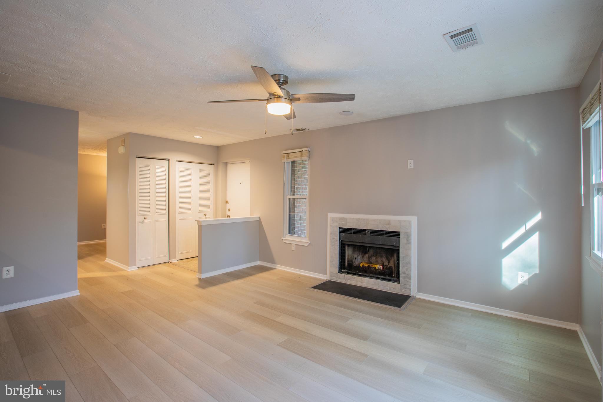 7537 Weather Worn Way, Unit A Columbia, MD 21046 - Photo 5 of 23 a living room with a fireplace and wooden floor