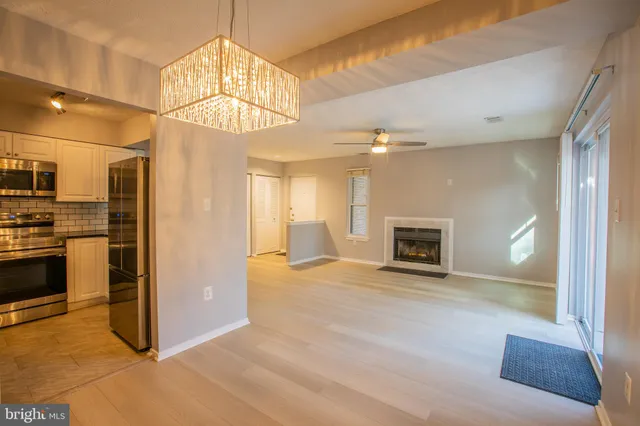 a view of a refrigerator in kitchen and an empty room
