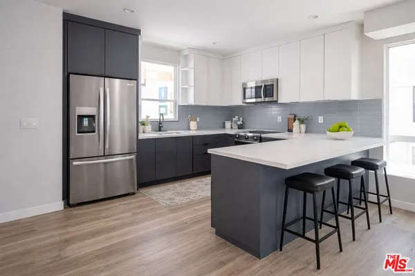 a kitchen with kitchen island a counter space a sink appliances and cabinets
