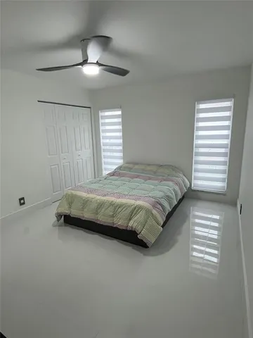 a bedroom with a bed and a ceiling fan