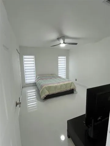 a bedroom with a bed and a ceiling fan