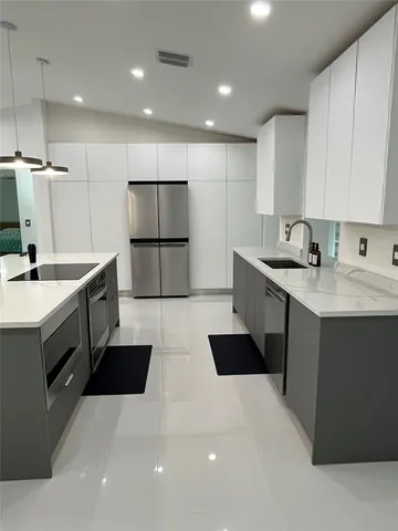 a view of a refrigerator in kitchen and an empty room