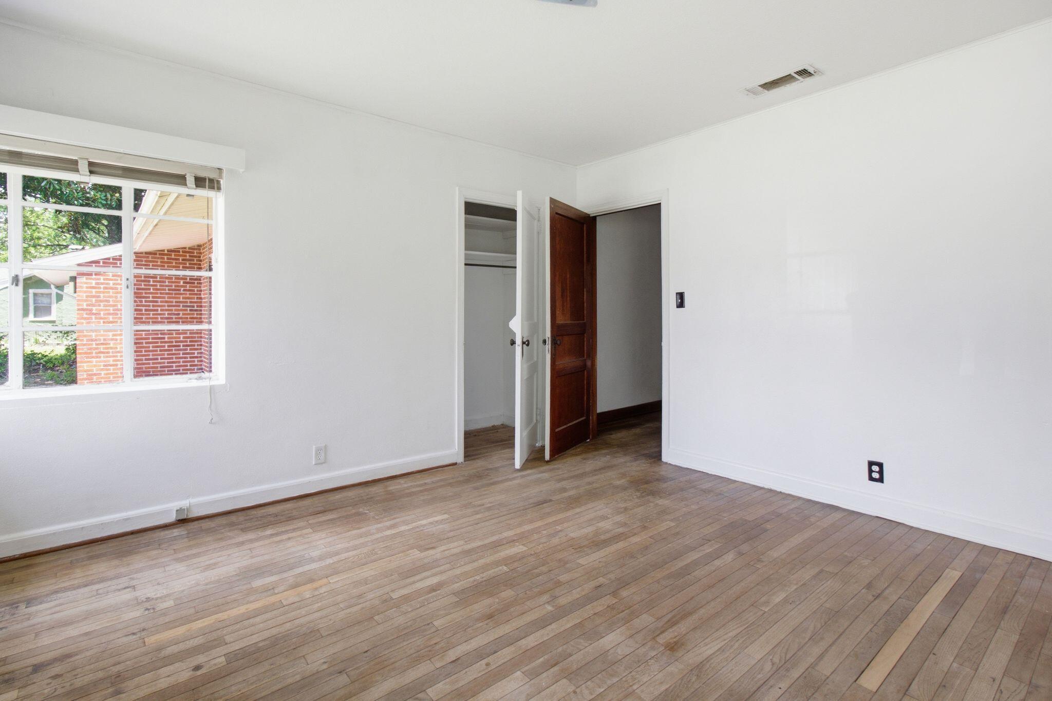 855 North Pearl Street Crestview, FL 32536 - Photo 17 of 31 an empty room with wooden floor and windows