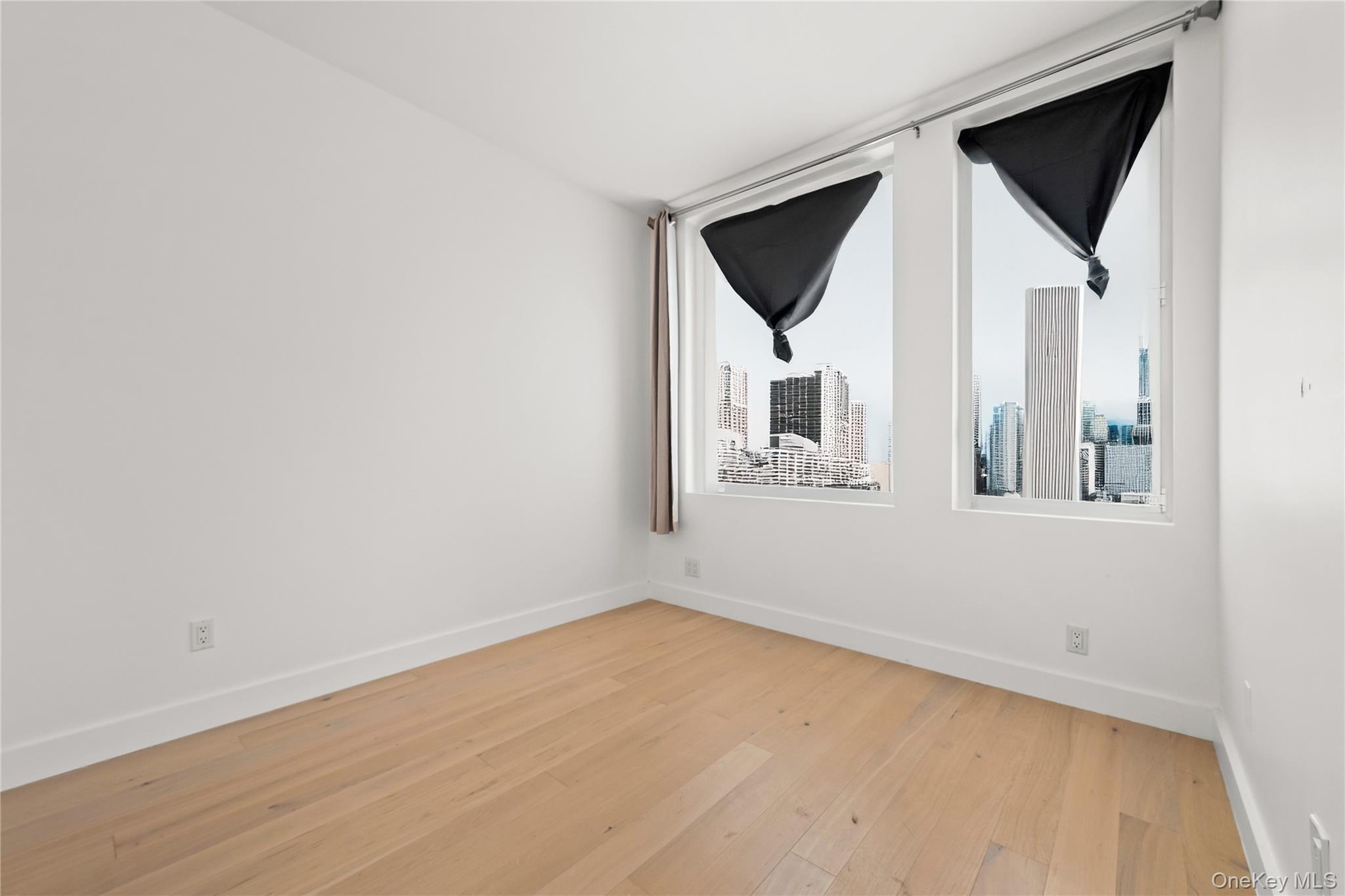 13618 Maple Avenue, Unit 5G Queens, NY 11355 - Photo 6 of 16 Empty room with light wood finished floors and baseboards