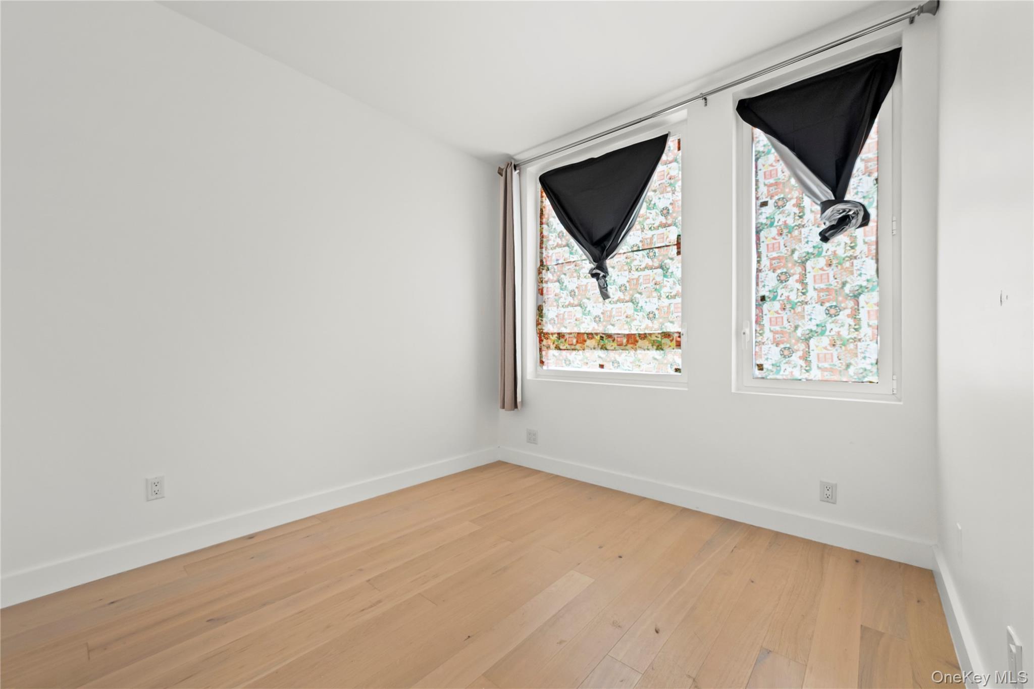 13618 Maple Avenue, Unit 5G Queens, NY 11355 - Photo 7 of 16 Unfurnished room with light wood finished floors and baseboards