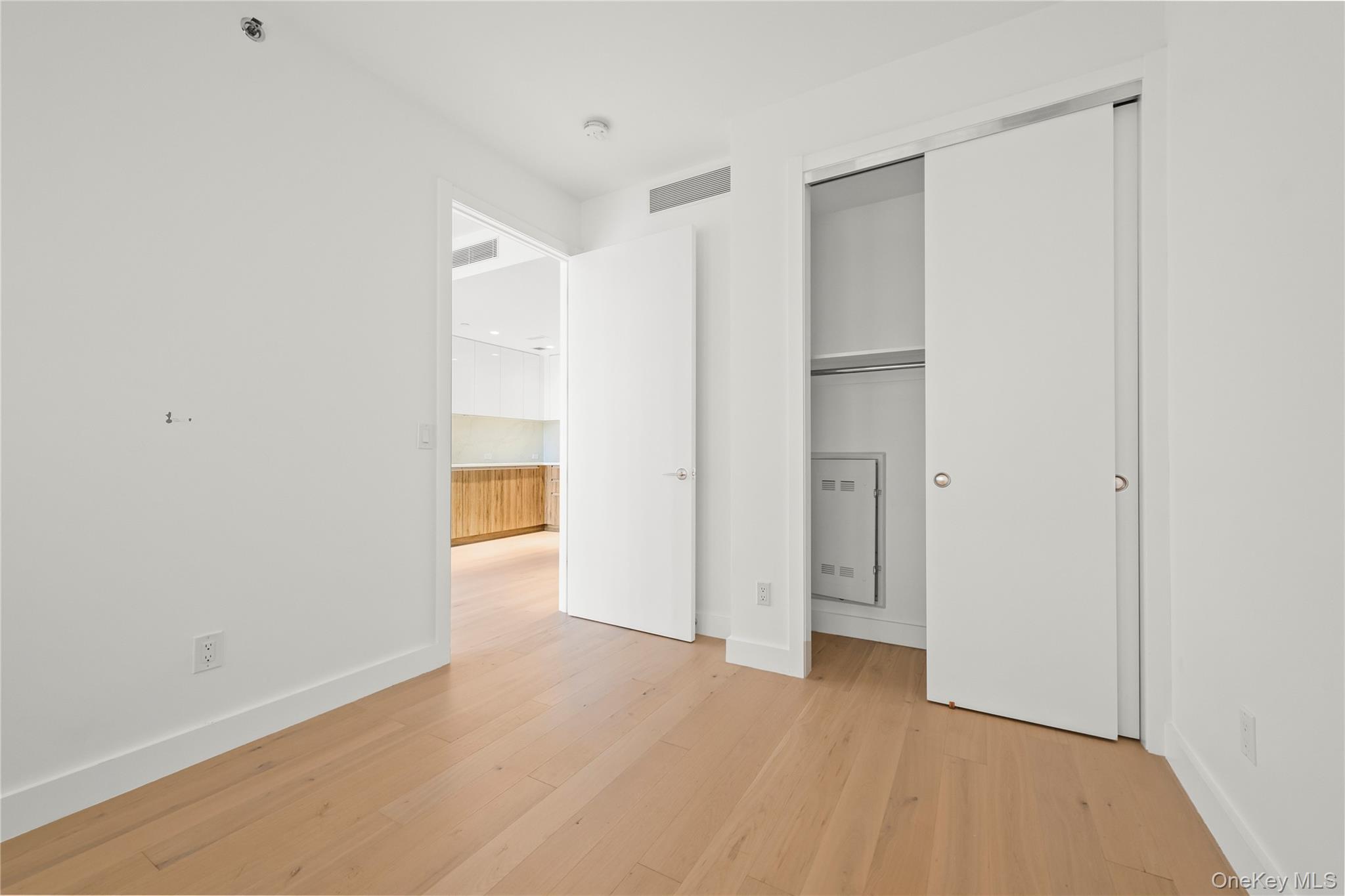 13618 Maple Avenue, Unit 5G Queens, NY 11355 - Photo 8 of 16 Unfurnished bedroom featuring light wood finished floors and a closet