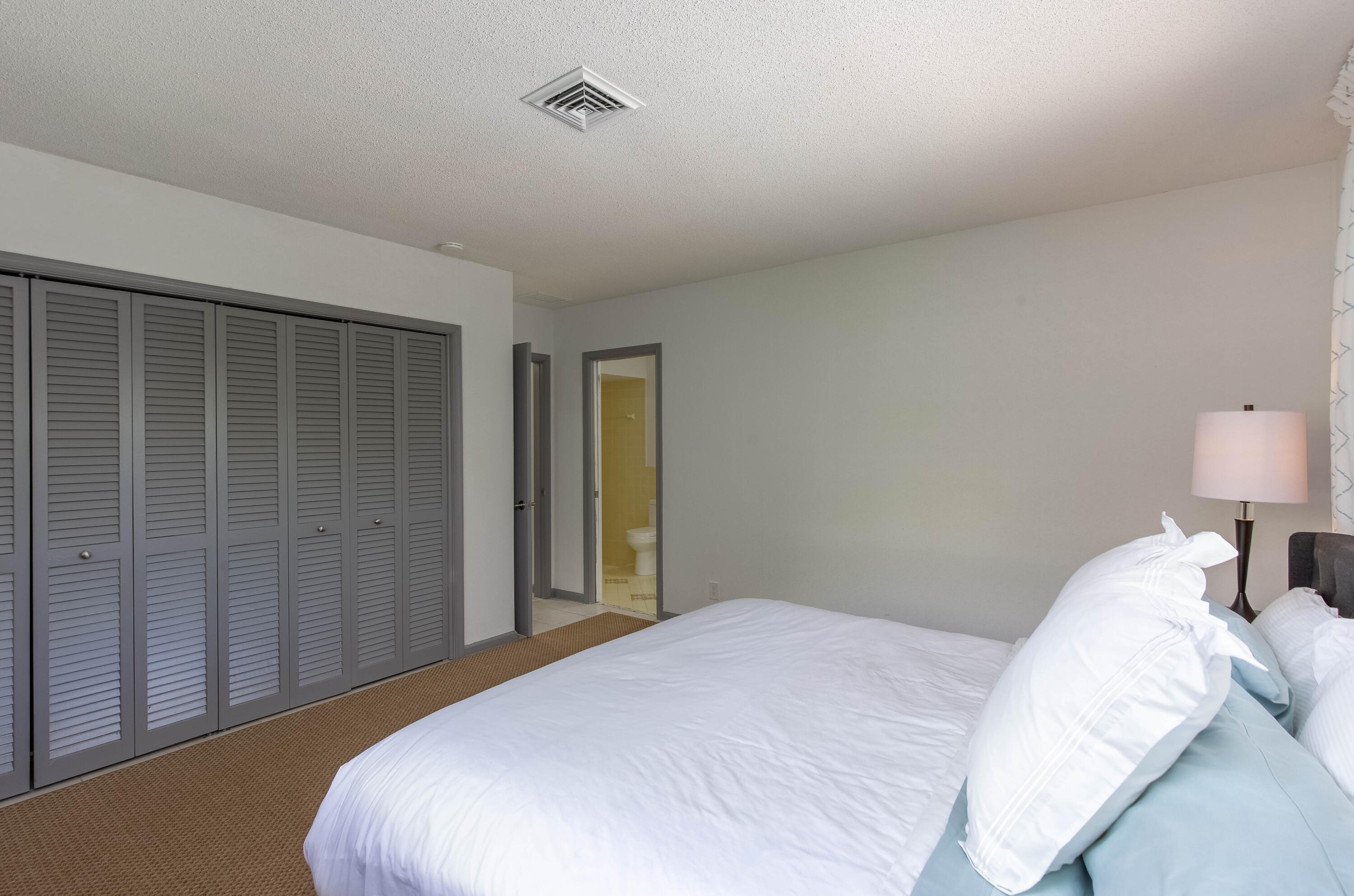 1323 Sugar Plum Drive Boca Raton, FL 33486 - Photo 13 of 28 a bedroom with a bed and a lamp