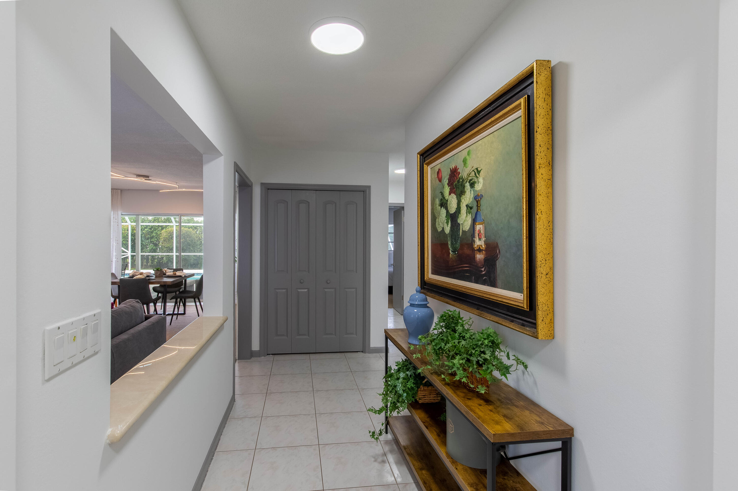 1323 Sugar Plum Drive Boca Raton, FL 33486 - Photo 2 of 28 a hallway with painting and potted plants