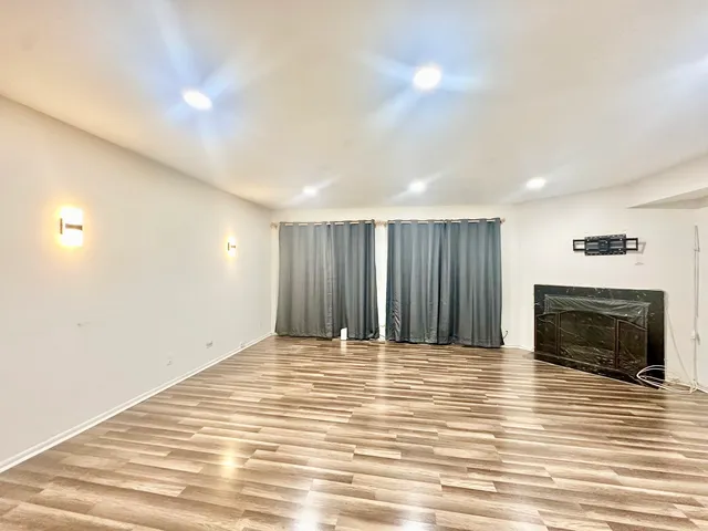 a view of empty room with wooden floor and fireplace