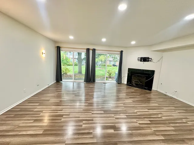 a view of empty room with wooden floor and fireplace