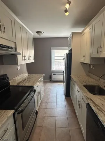 a kitchen with a stove sink and cabinets