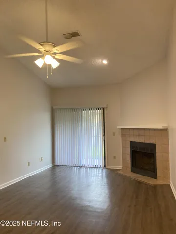 an empty room with windows and fireplace