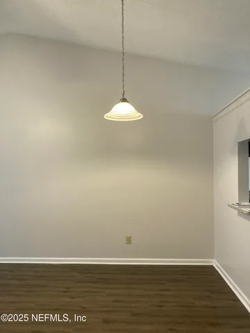 a view of a room with wooden floor and white walls