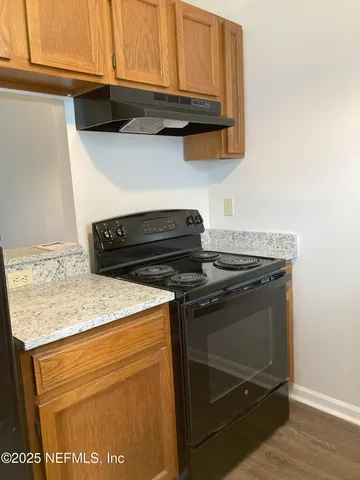 a view of kitchen island with granite countertop stove top oven