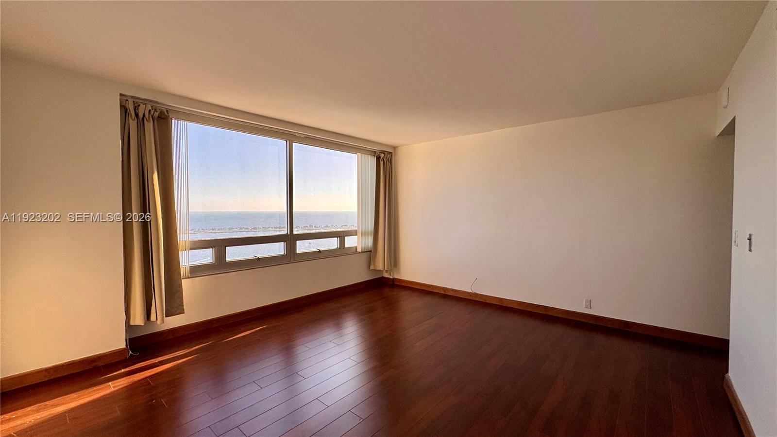 1541 Brickell Avenue, Unit C2705 Miami, FL 33129 - Photo 9 of 13 an empty room with wooden floor and windows