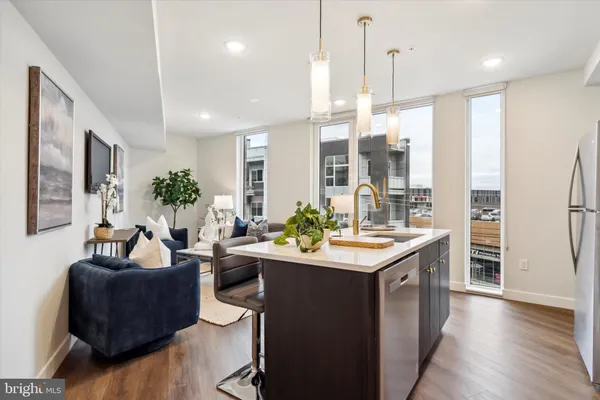 a kitchen with a refrigerator a sink dishwasher and a flat screen tv