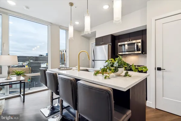 a kitchen with a sink and chairs