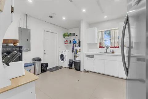 a kitchen with a sink a refrigerator and cabinets