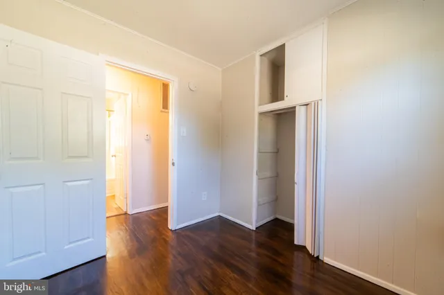 an empty room with wooden floor and closet