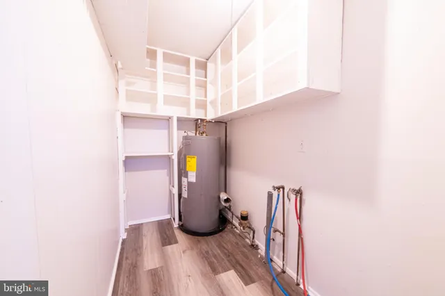 an empty room with wooden floor fireplace and windows